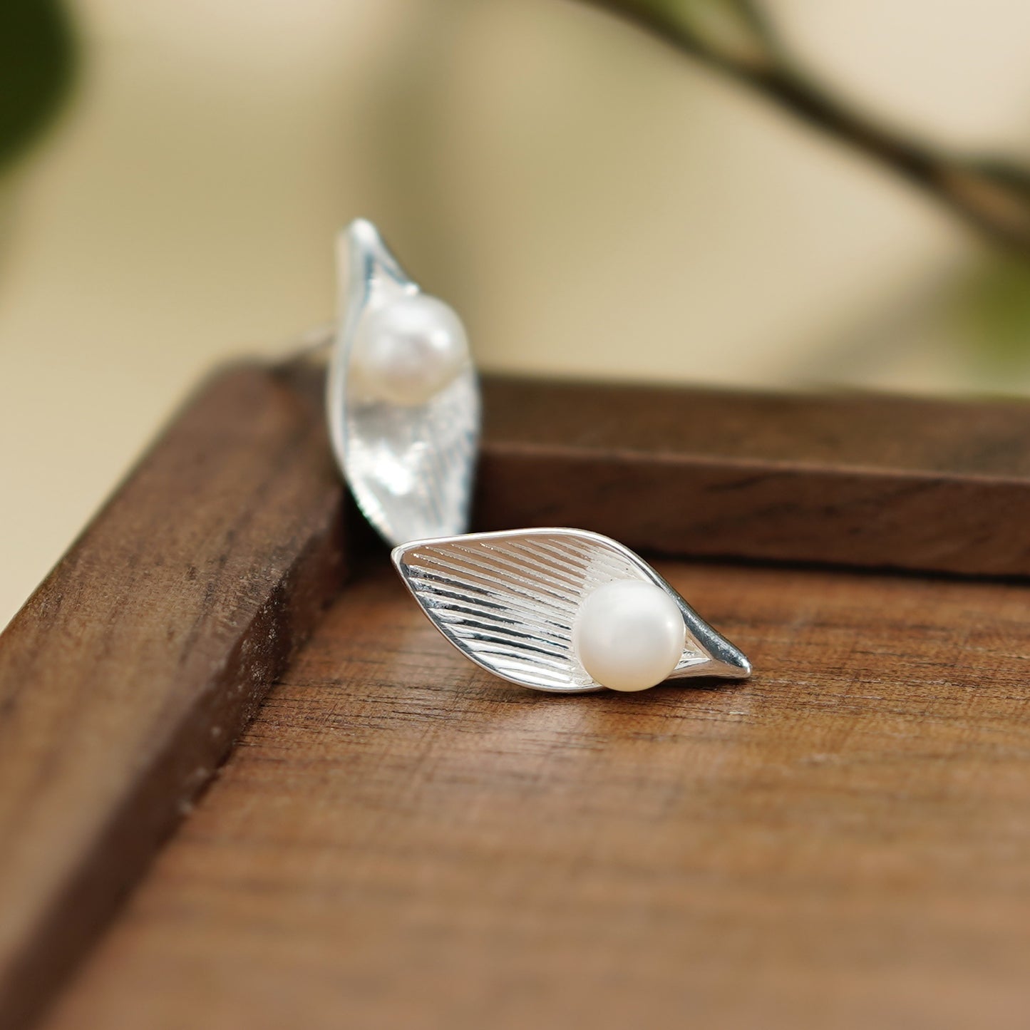 Pearl stud earrings with leaf design