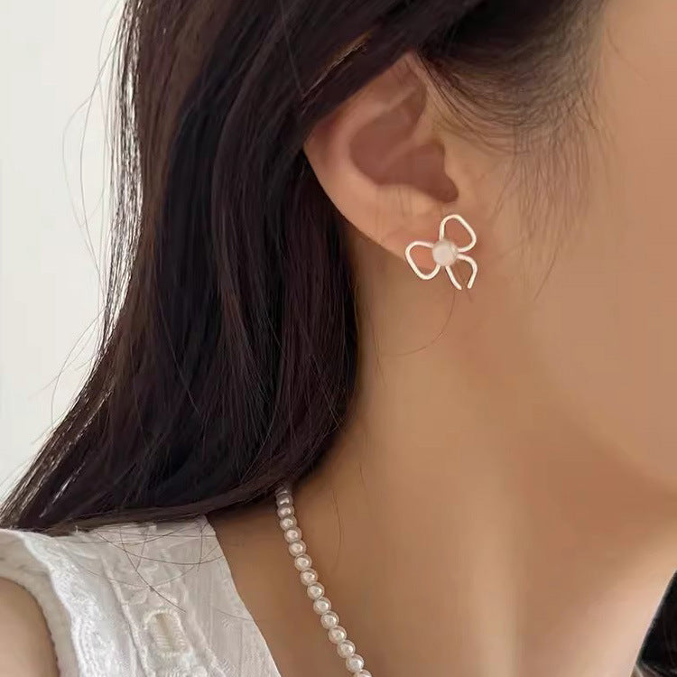 Pearl stud earrings with bow design