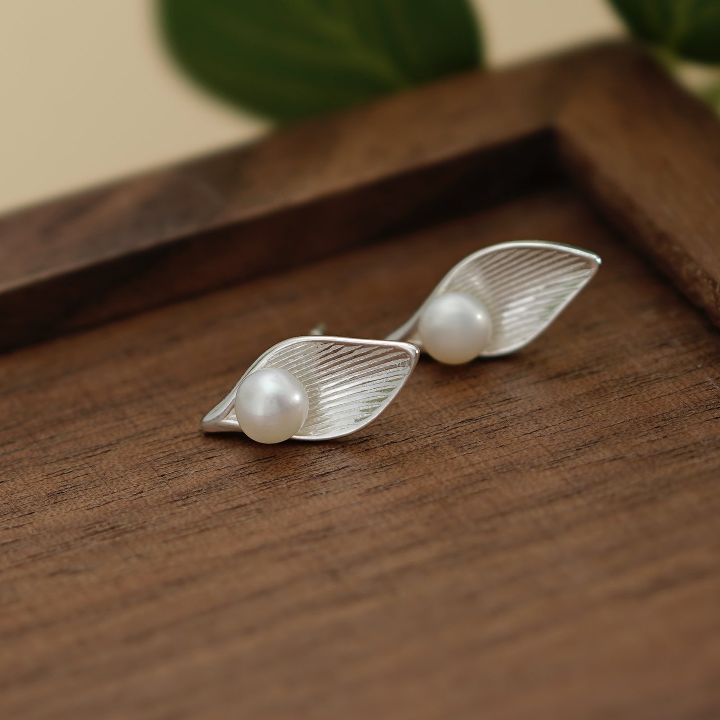 Pearl stud earrings with leaf design